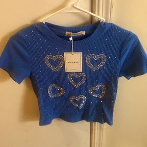 Small blue crop top with hearts on the shirt.